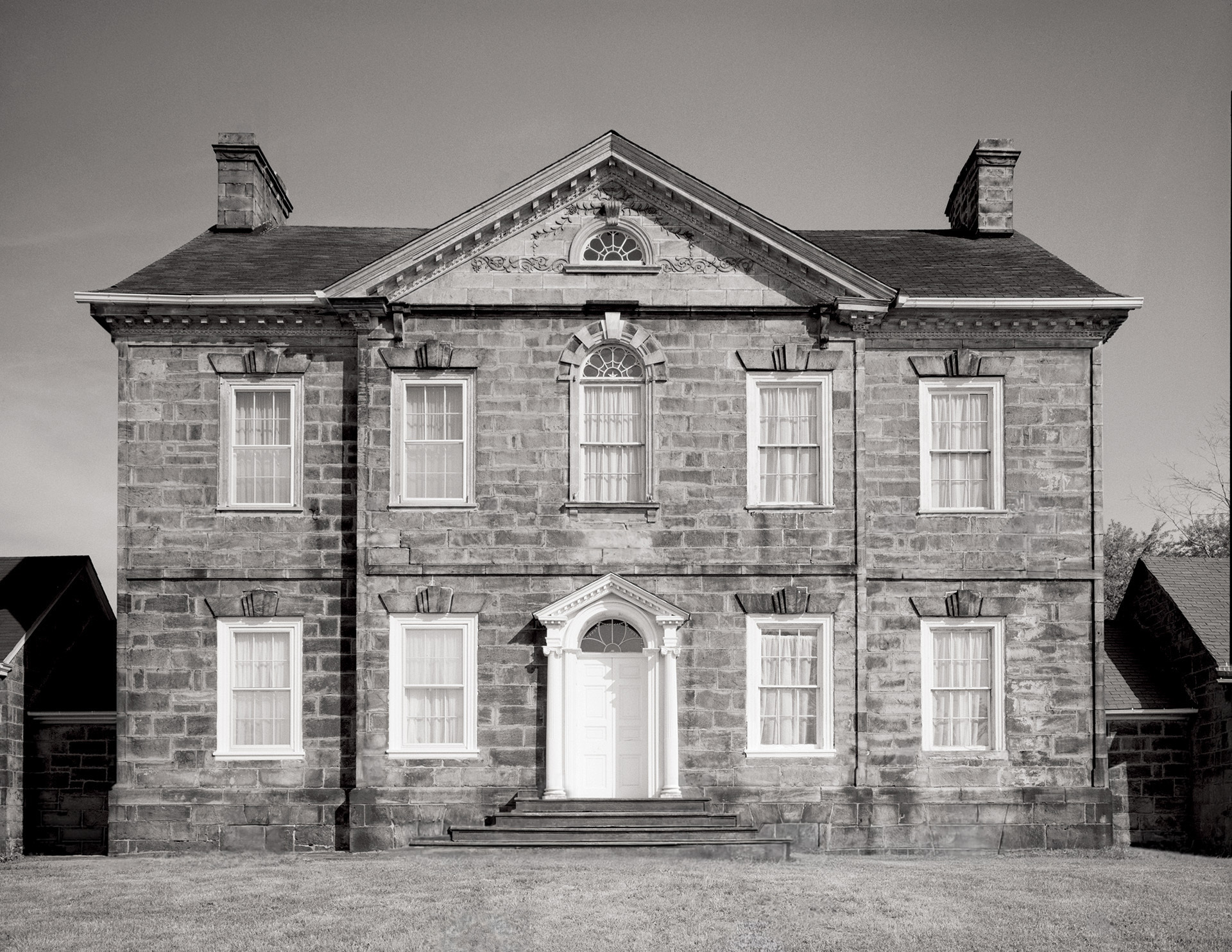 Palladian style house showcasing door mouldings, window mouldings, steps to entrance, and almost perfect symmetry.