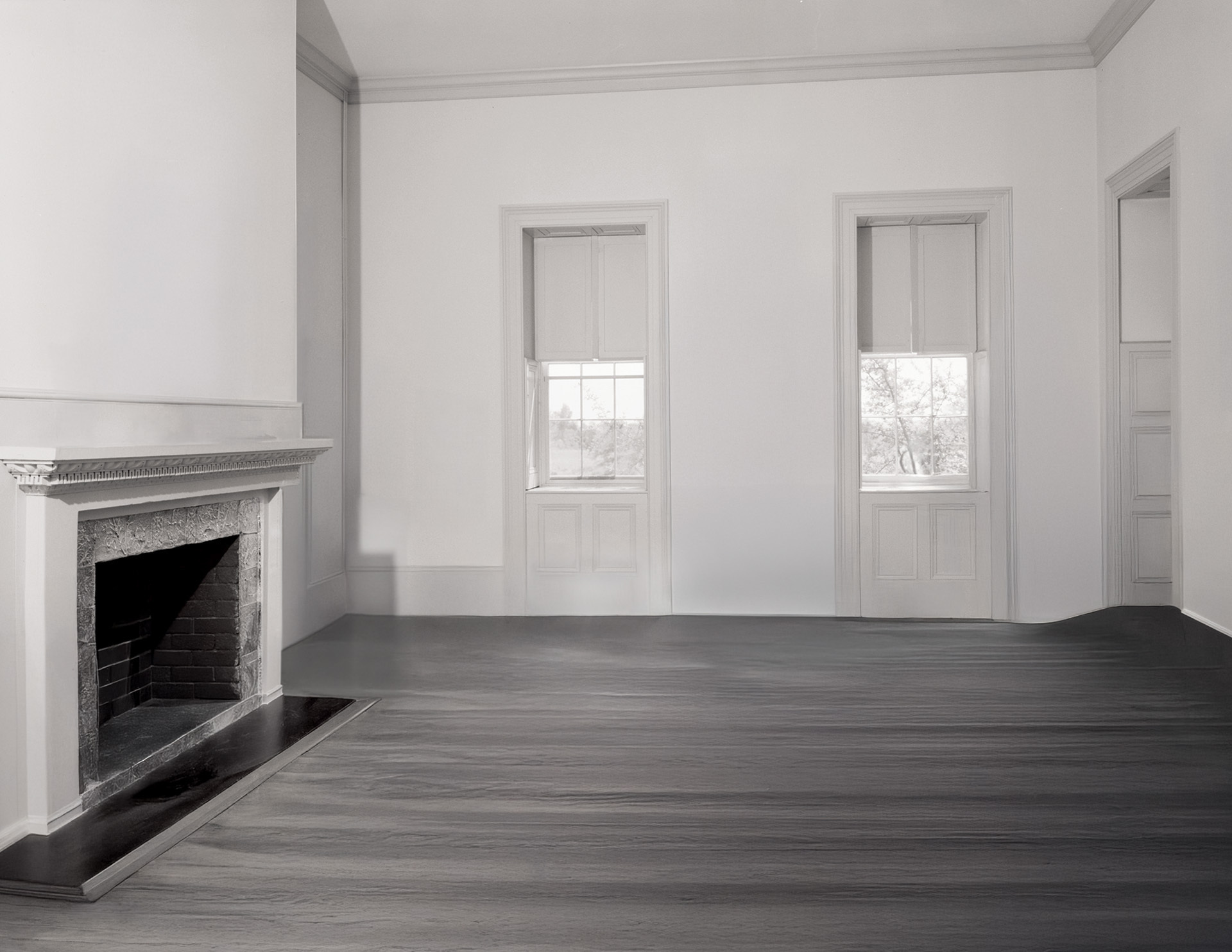 Whitewashed palladian style room featuring cornice mouldings, hardwood flooring, and door mouldings.